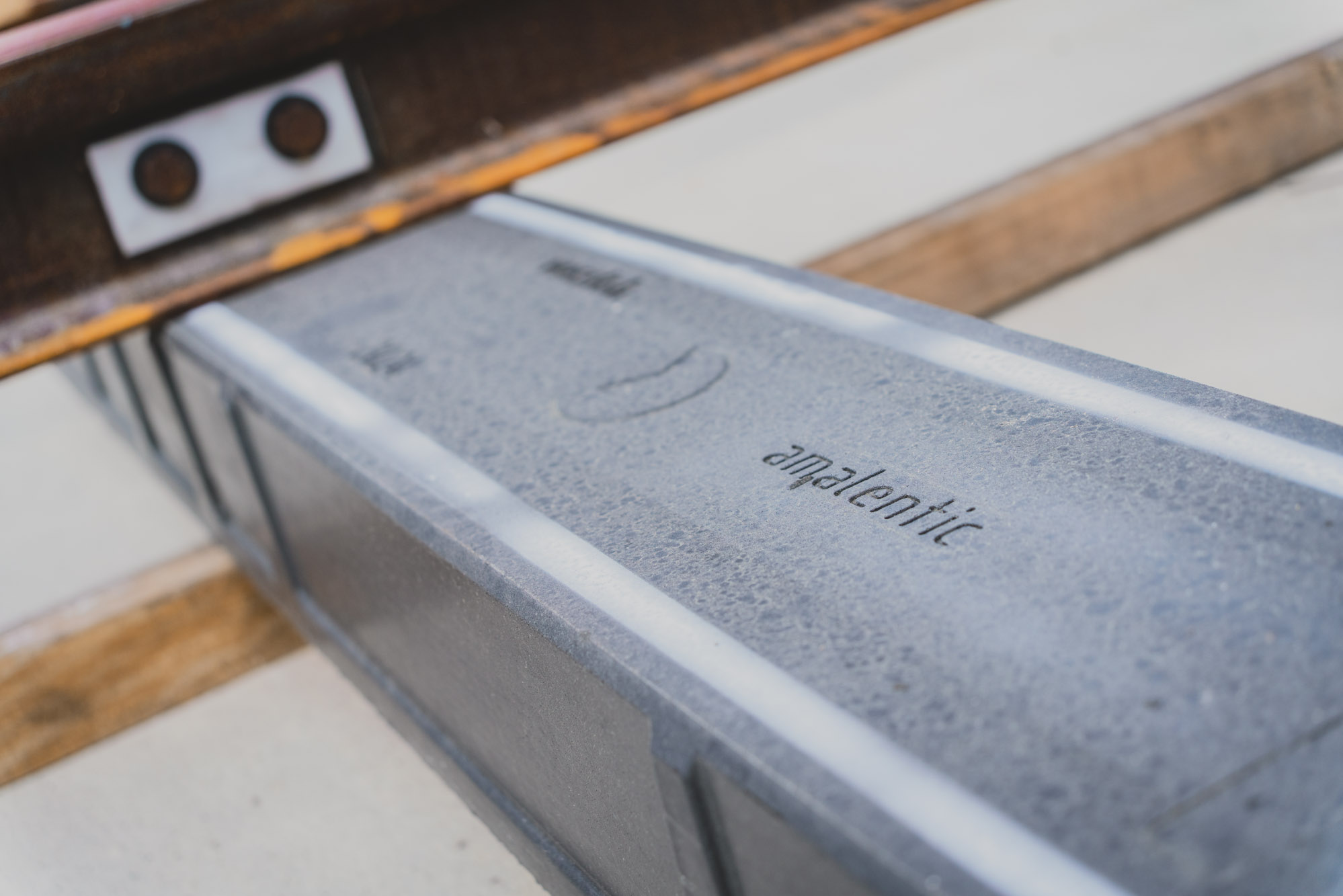 Close-up of a composite sleeper with the inscription “amalentic” beneath a rail