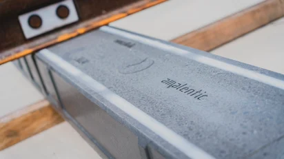 Close-up of a composite sleeper with the inscription “amalentic” beneath a rail