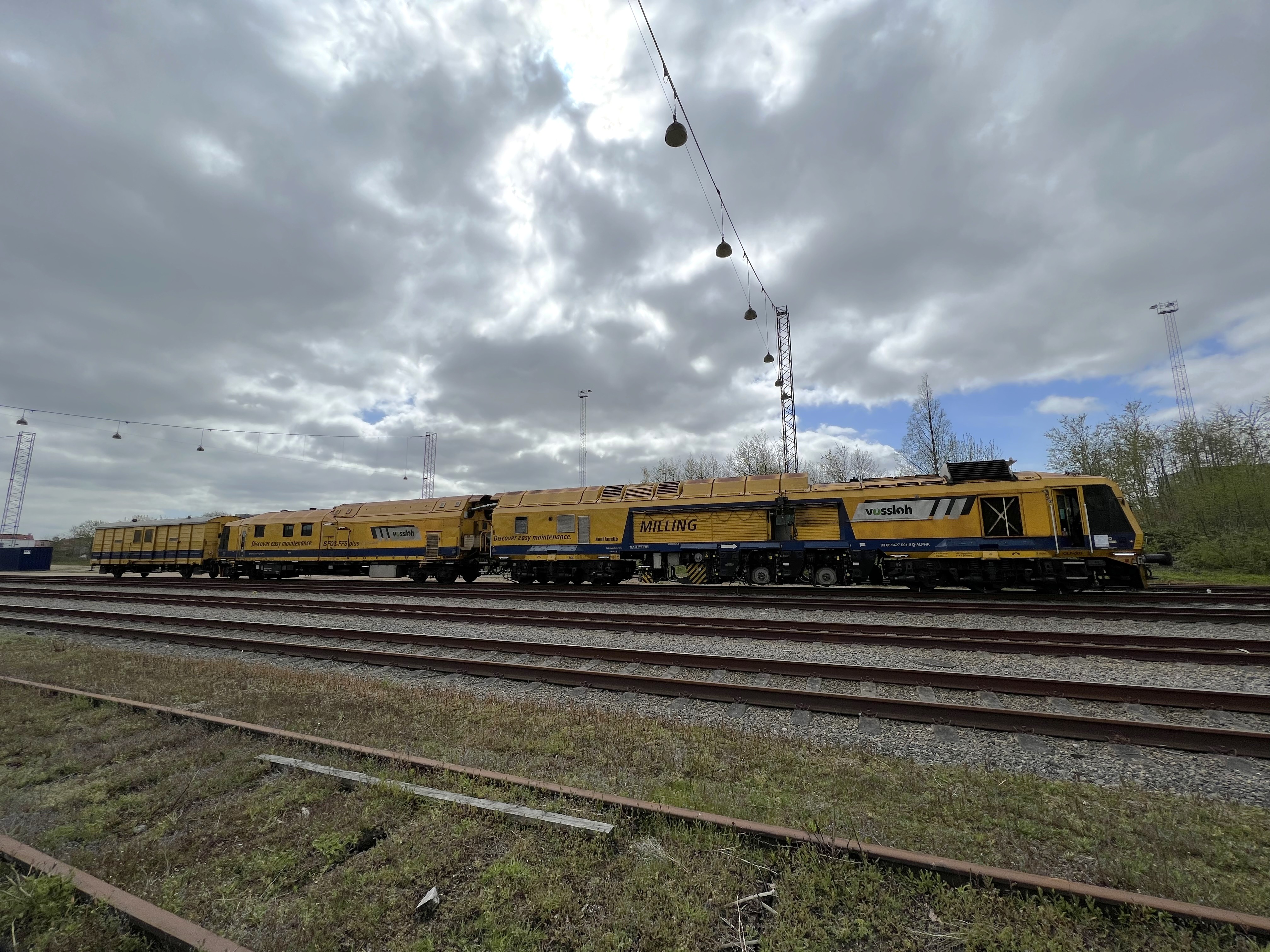 Milling train SF03 on tracks, cloudy sky