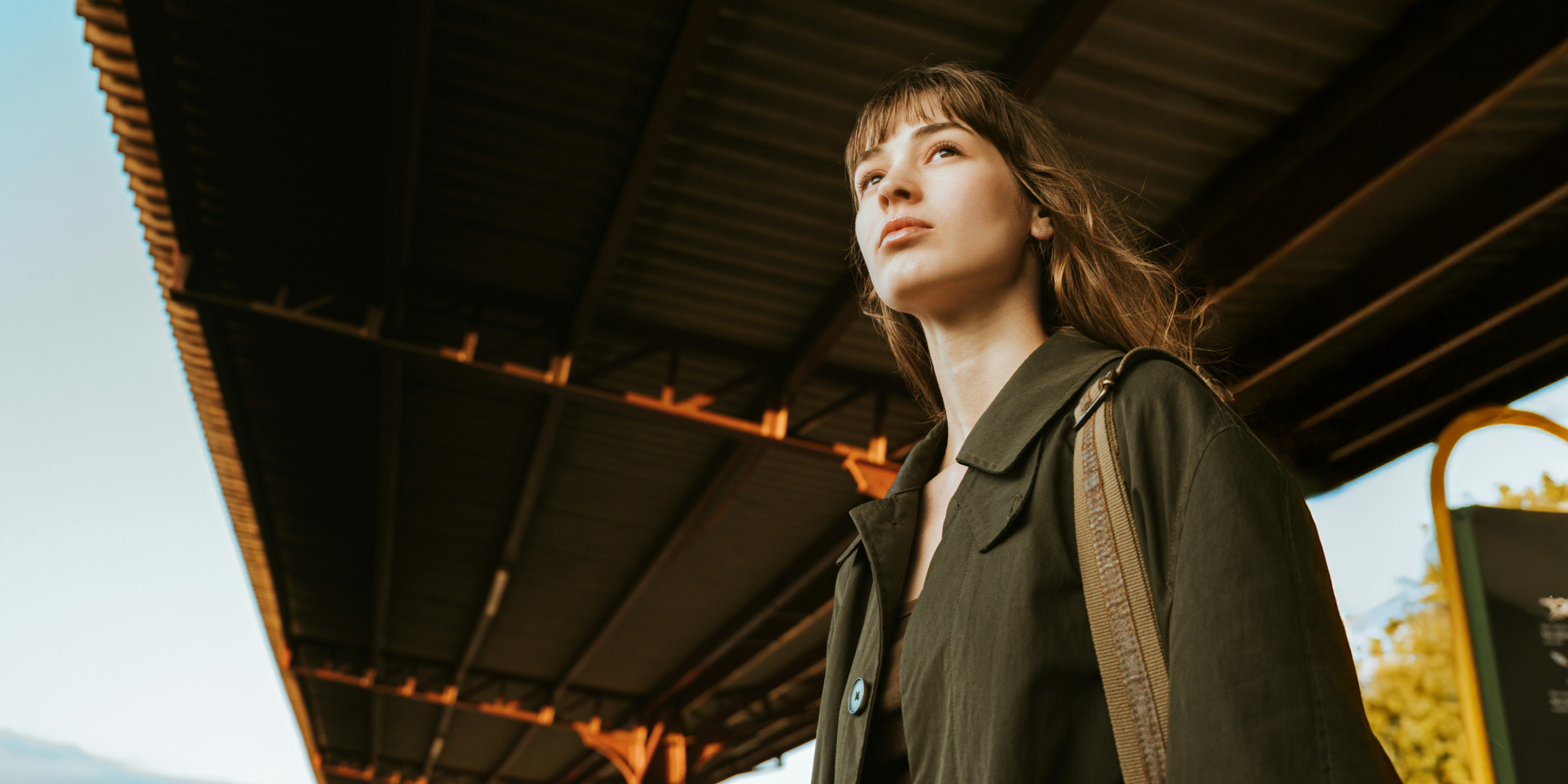 Frau steht unter einem Dach und wartet