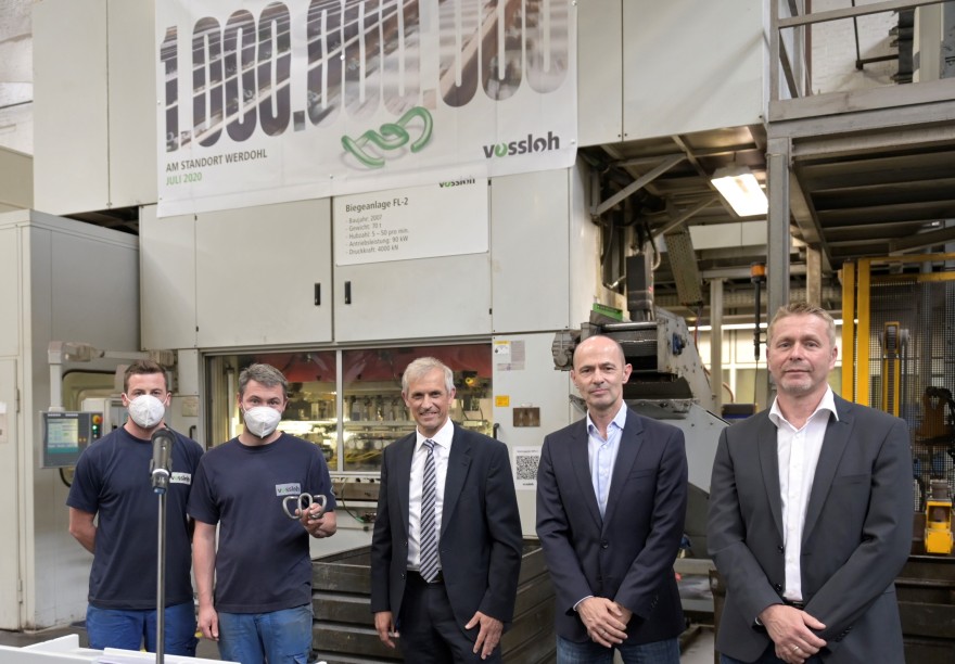 Our photo, from left to right: Tobias Baum and Philipp Holtmann from Production handing over the just-bent one-billionth tension clamp to Christian Renners, Oliver Schuster, and Works Council member Martin Klaes. In this instance, the speakers were allowed to briefly remove their masks.