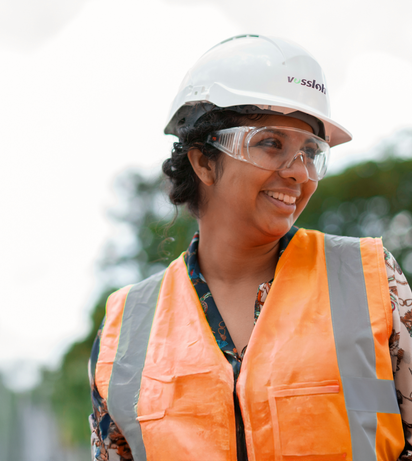 Smiling woman with work helmet and safety vest